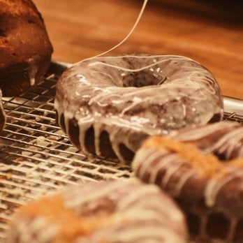 Chocolate-glazed donuts on a wire cooling rack with chocolate drizzle